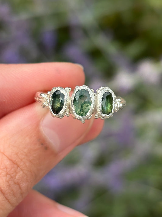 A moss agate ring with two teal sapphires in silver. 
